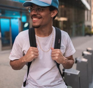 man in white crew neck t-shirt wearing blue cap and black sunglasses